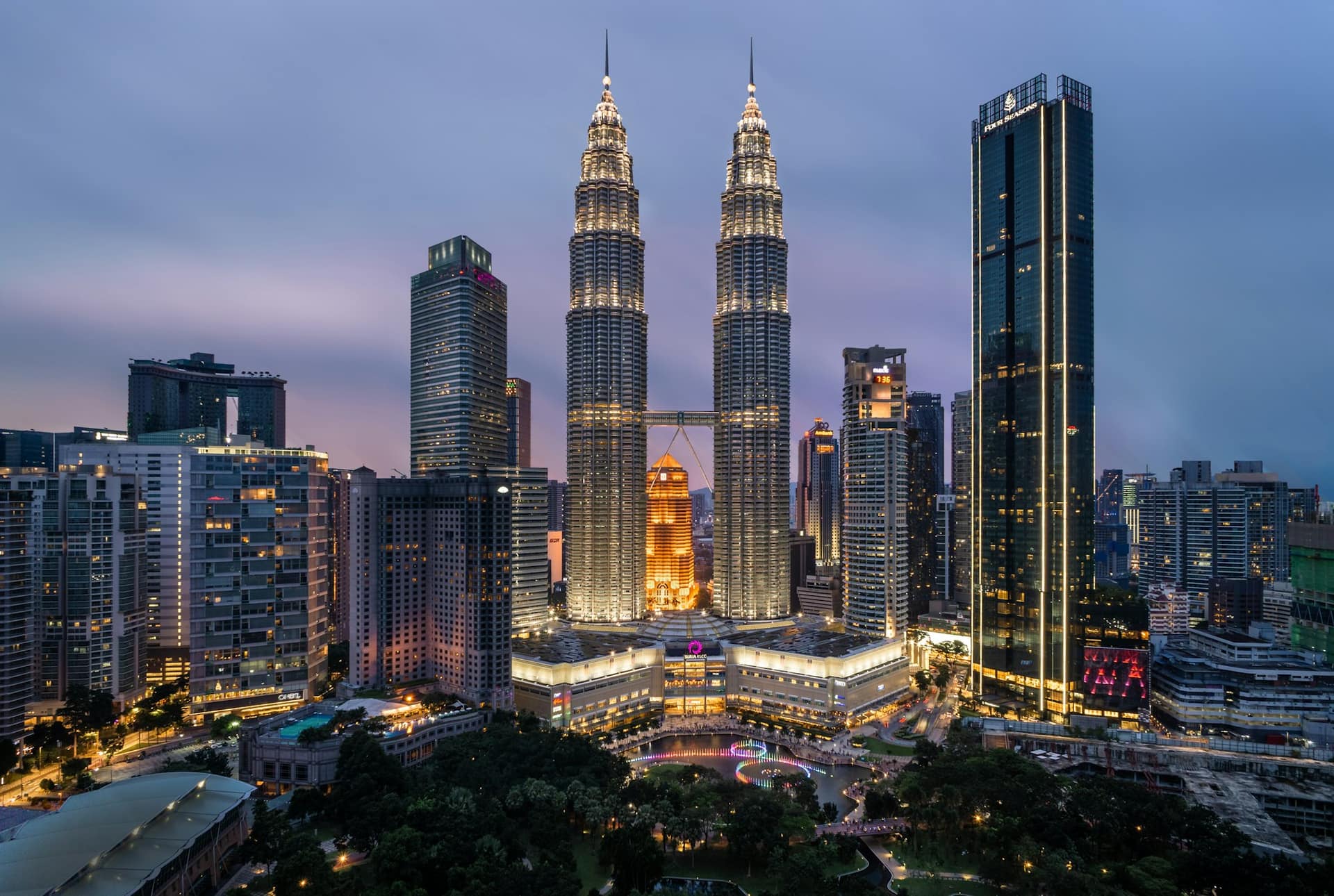 The Kuala Lumpur city skyline at golden hour, including the Petronas Towers